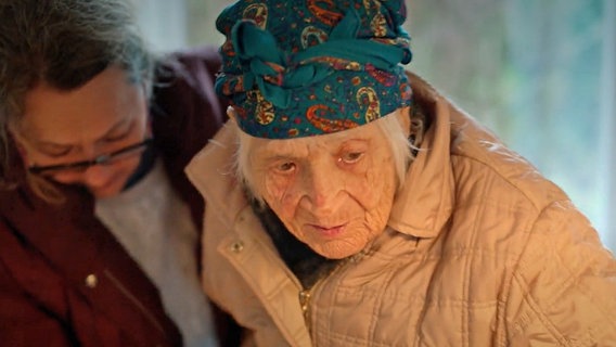 Eine Helferin stützt eine alte Frau, die aus der Ukraine nach Deutschland geflüchtet ist © NDR 