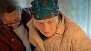 Eine Helferin stützt eine alte Frau, die aus der Ukraine nach Deutschland geflüchtet ist © NDR 