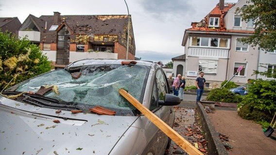 Eine Dachlatte steckt in der Windschutzscheibe eines parkenden Autos in Paderborn. Ein Unwetter hat in der Stadt große Schäden angerichtet. © dpa-Bildfunk 