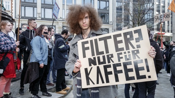 Ein Demonstrant hält auf dem Hamburger Gänsemarkt ein Schild mit der Aufschrift "Filter? Nur für Kaffee!". © dpa Bildfunk Foto: Markus Scholz