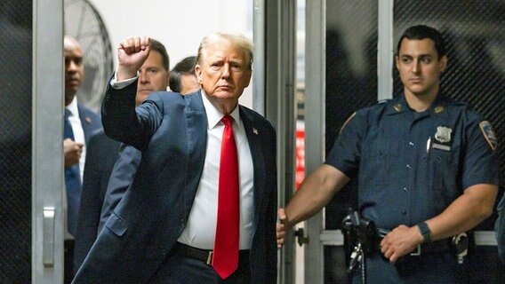 Der ehemalige US-Präsident Donald Trump (M.) beim Betreten eines Gerichtssaals des Strafgerichts in Manhattan (New York). © dpa bildfunk/Pool EPA/AP Foto: Justin Lane