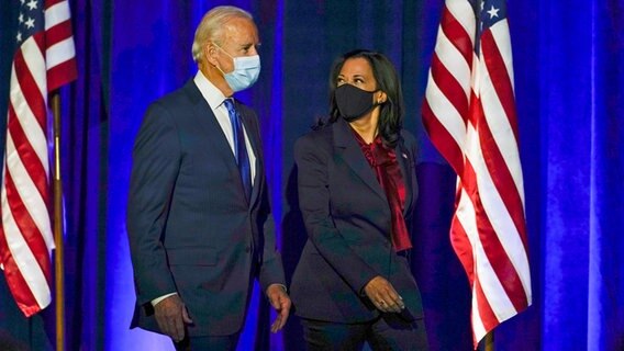 Joe Biden und und Kamala Harris betreten für eine Ansprache in Wilmington (Delaware) eine Bühne und tragen Mund-Nasen-Schutz. © dpa-Bildunk Foto: Carolyn Kaster/AP/dpa