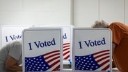 Zwei Menschen bei der Stimmabgabe zur US-Präsidentschaftswahl in einem Wahllokal. © dpa picture alliance / Sipa USA 