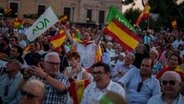 Rechtsextreme VOX-Anhänger winken während der Abschlusskundgebung auf dem Colon-Platz in Madrid © Manu Fernandez/AP/dpa 
