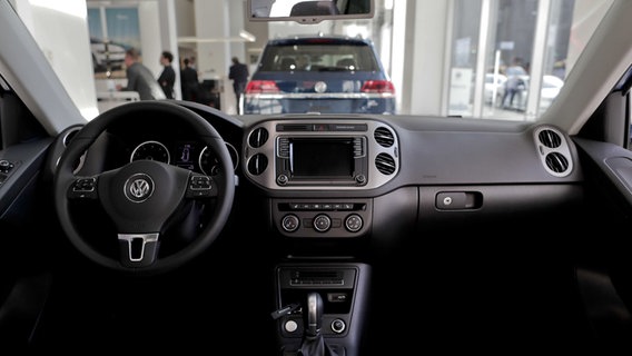 Blick auf den Fahrerbereich eines VW Tiguan. Durch die Frontscheibe ist ein VW-Showroom zu sehen. © dpa Bildfunk Foto: Julie Jacobson