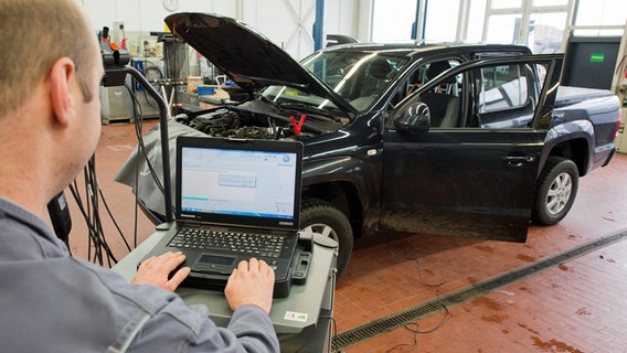 Ein Kfz-Mechaniker lädt ein Software-Update für das Steuergerät Motorelektronik auf einen Volkswagen Amarok mit einem 2,0-Liter-Dieselmotor. © dpa Foto: Julian Stratenschulte