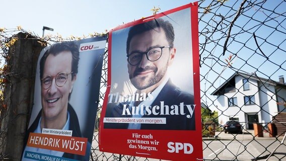 Wahlplakate mit Porträts der NRW-Spitzenkandidaten von CDU, Ministerpräsident Hendrik Wüst (l), und SPD, Thomas Kutschaty, hängen an einem Zaun. © picture alliance / Goldmann | Goldmann 