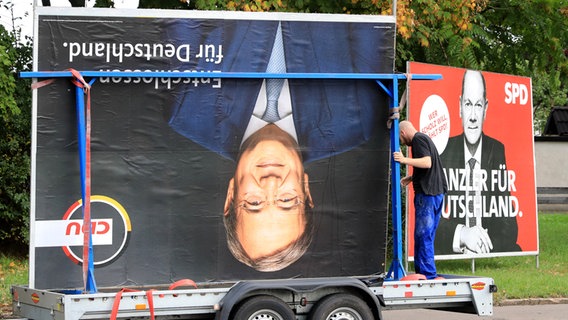 Nach der Bundestagswahl werden Wahlplakate abgebaut: Ein CDU-Plakat mit Armin Laschet steht Kopf, daneben ein Plakat mit Olaf Scholz.(Archivfoto) © Peter Gercke/dpa-Zentralbild/dpa 
