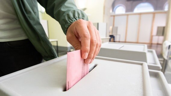 Ein Mann wirft seinen Stimmzettel für die Bundestagswahl in eine Wahlurne © picture alliance/dpa Foto: Julian Stratenschulte