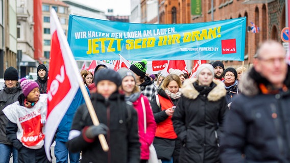 Demonstrierende laufen bei einem ver.di-Warnstreik mit Plakaten durch eine Stadt. © dpa bildfunk Foto: Moritz Frankenberg/
