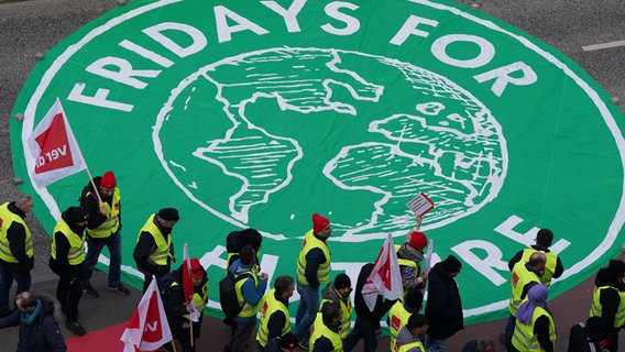Teilnehmer demonstrieren in der Hamburger Innenstadt und gehen an einem großen Fridays for Future-Logo vorbei. © dpa-Bildfunk Foto: Marcus Brandt/dpa
