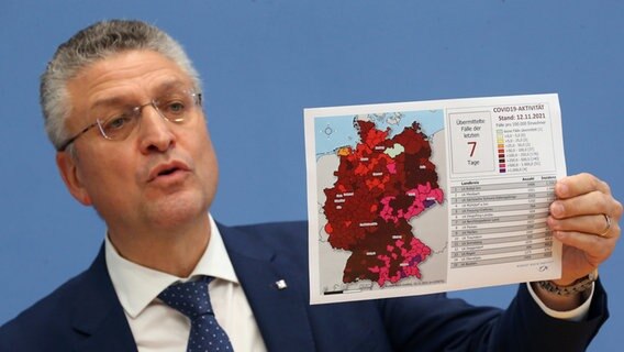 RKI-Präsident Lothar Wieler hält bei einer Bundespressekonferenz eine Karte mit den Sieben-Tage-Inzidenzen in den Landkreisen hoch. © dpa-Bildfunk Foto: Wolfgang Kumm/dpa