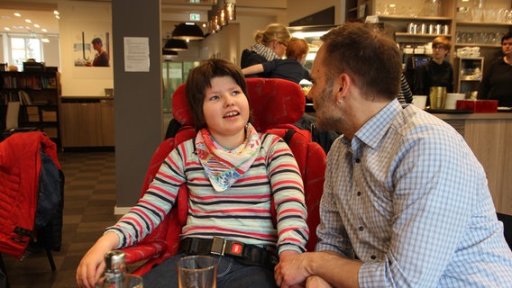 Ein behindertes Mädchen  mit Ihrem Vater im Café. © NDR Foto: Susanne Schäfer