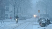 Hamburg: Ein Fahrradfahrer fährt auf einer verschneiten Straße. © dpa-Bildfunk Foto: Marcus Brandt