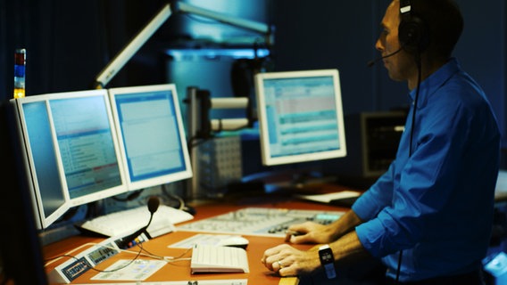 Ein Moderator steht vor dem Mischpult in einem Hörfunkstudio © NDR 