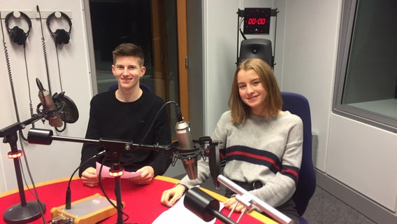 Zwei Schülerpraktikannten sitzen vor Radiomikrofonen und lächeln in die Kamera © NDR Foto: Jürgen Kopp
