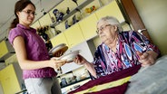 Projekt Wohnen für Hilfe: Eine junge und eine alte Frau bereiten in einer Küche gemeinsam ihr Mittagessen vor. © picture alliance / dpa Foto: Susann Prautsch