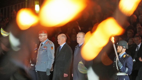 Der scheidende Bundeskanzler Olaf Scholz (M.) steht mit Verteidigungsminister Boris Pistorius (r.) und General Carsten Breuer, Generalinspekteur der Bundeswehr, beim großen Zapfenstreich der Bundeswehr anlässlich seiner Verabschiedung. © Michael Kappeler/dpa 