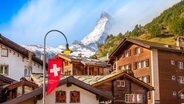 Häuser in Zermatt (Schweiz) mit dem schneebedeckten Matterhorn in Hintergrund. © picture alliance / Zoonar Foto: Nataliya Nazarova