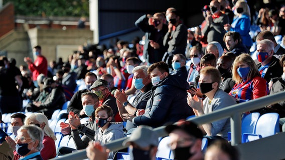 Zuschauer in einem Fußballstadion, die Mund-Nasen-Bedeckungen tragen. © dpa picture alliance/Pool Photo via AP Foto: Facundo Arrizabalaga