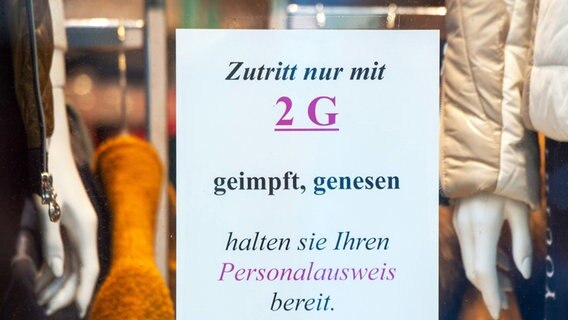 auf dem Schild am Eingang eines Bekleidungsgeschäfts klebt ein Schild, auf dem steht: "Zutritt nur mit 2G". © dpa Foto: Stefan Sauer