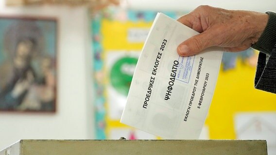 Ein Mann wirft seinen Wahlzettel während der Präsidentschaftswahlen in Zypern in eine Wahlurne. © dpa bildfunk/AP Foto: Petros Karadjias