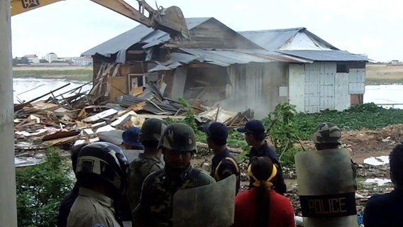 Ein Bagger zerstört ein Haus. © ICIJ 