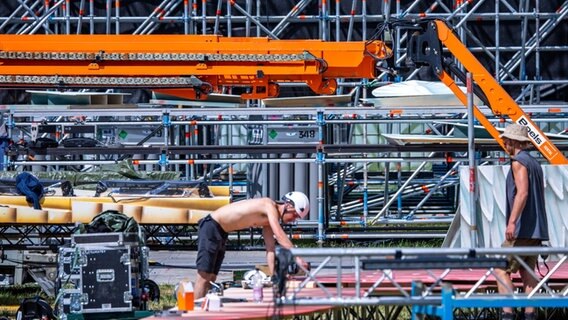Gerüstbauer bauen eine der Bühnen für das Musikfestival Airbeat One auf dem Flugplatz auf. © dpa Foto: Jens Büttner