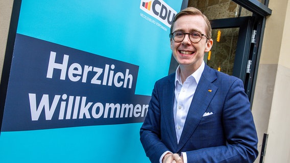Der Bundestagsabgeordnete Philipp Amthor (CDU) steht nach einer Pressekonferenz neben einem Schild mit der Aufschrift "Herzlich Willkommen". © dpa-Bildfunk Foto: Jens Büttner