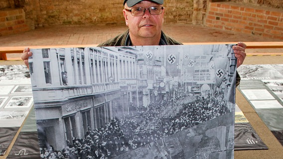 Der Mitarbeiter des städtischen Museum in Anklam, Peer Wittig, zeigt in der Sonderausstellung "Anklam im Krieg - eine Chronik" ein Ausstellungsbanner. © dpa-Bildfunk Foto: Stefan Sauer