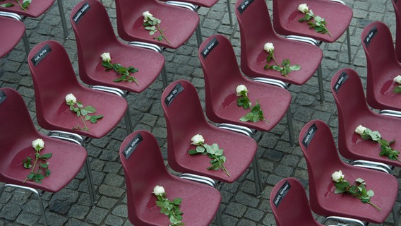 Stühle mit Namensschildern von Opfern und weißen Rosen stehen auf dem Marktplatz von Anklam. © dpa-Bildfunk Foto: Stefan Sauer