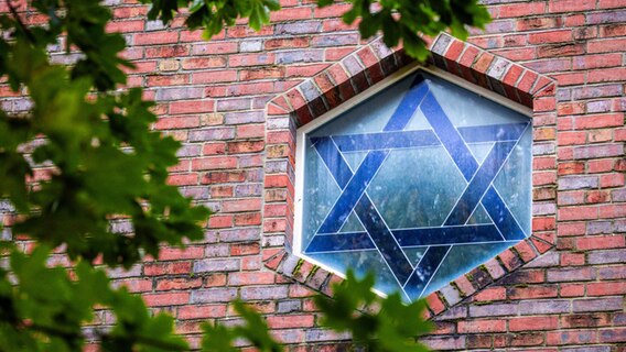 Der Davidstern ist in einem Fenster einer Synagoge in Schwerin zu sehen. © dpa Foto: Jens Büttner