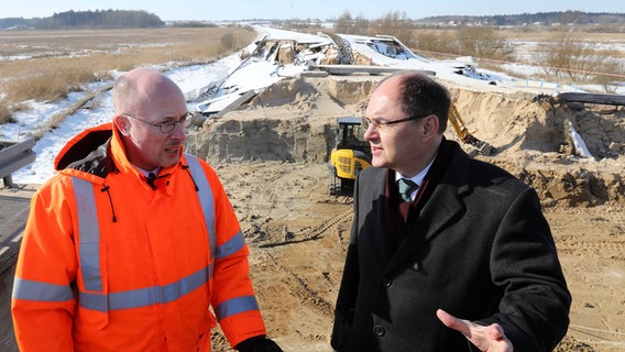 Bundesverkehrsminister Christian Schmidt (r., CSU) informiert sich an der abgesackten Ostseeautobahn A 20 über die Schäden und lässt sich von Landesverkehrsminister Christian Pegel (SPD) über die Situation informieren. © dpa-Bildfunk Foto: Bernd Wüstneck