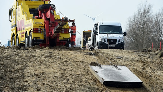 Mit einem Abschleppwagen werden die Asphaltbrocken aus der Einsturzstelle der A 20 gezogen. © dpa-Bildfunk Foto: Stefan Sauer