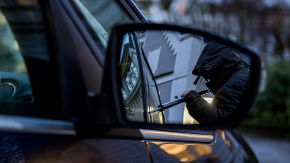 Ein Mann versucht in einer gestellten Szene eine Autotür mit einer Metallstange aufzubrechen. © dpa-Bildfunk Foto: Axel Heimken