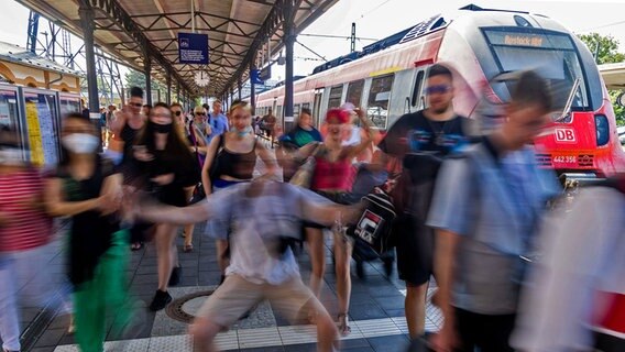 Fahrgäste steigen im Bahnhof Warnemünde aus einer S-Bahn. © dpa Foto: Jens Büttner
