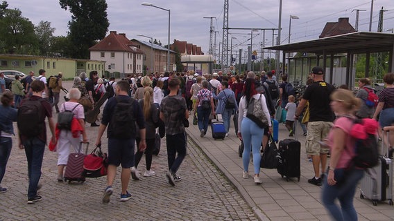 Viele Reisende versammelten sich vor einem Bus © NDR 