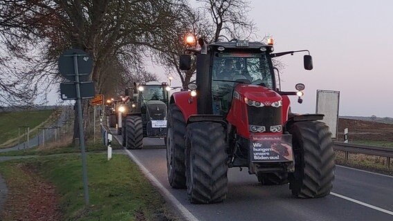 Traktoren mit Plakaten fahren im Konvoi auf einer Bundesstraße nach Schwerin. © Christoph Woest Foto: Christoph Woest