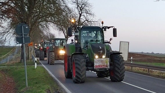 Traktoren mit Plakaten fahren im Konvoi auf einer Bundesstraße nach Schwerin. © Christoph Woest Foto: Christoph Woest