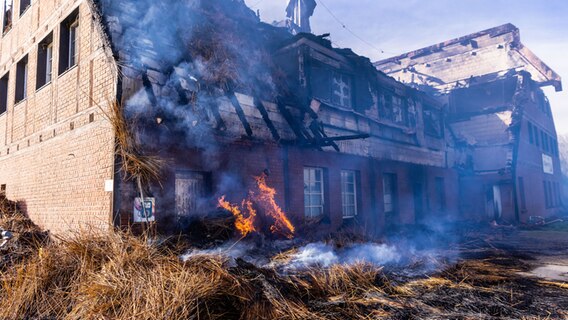 Groß Strömkendorf: Letzte offene Feuer brennen vor dem ehemaligen Hotel in dem Geflüchtete aus der Ukraine untergebracht waren. © dpa Foto: Jens Büttner