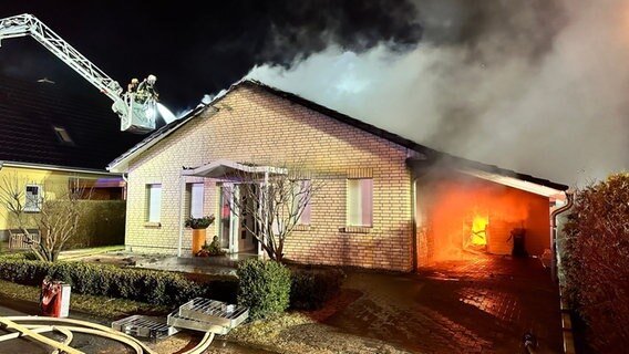Feuerwehr löscht Brand in einem Einfamilienhaus von einer Leiter aus. © NDR Foto: Felix Gadewolz