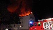 Der Dachstuhl eines Einfamilienhaus steht in Flammen. Die Feuerwehr versucht den Brand zu löschen. © NDR Foto: Ralf Drefin