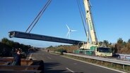 Mit einem Kran wird von einem Lkw ein Brückenteil für die Behelfsbrücke der A20 bei Tribsees abgeladen. © NDR Foto: Steffen Baxalary