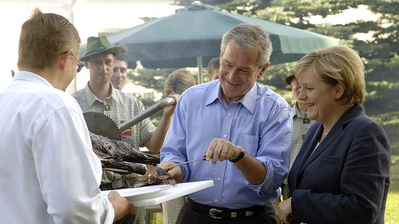 Bundeskanzlerin Angela Merkel und US-Präsident Bush 2006 beim Barbeque in Trinwillershagen © dpa 