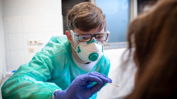 Mit einem Abstrichstäbchen nimmt ein Mitarbeiter eine Proben im Testzentrum für Corona-Verdachtsfälle. © dpa-Bildfunk Foto: Jens Büttner