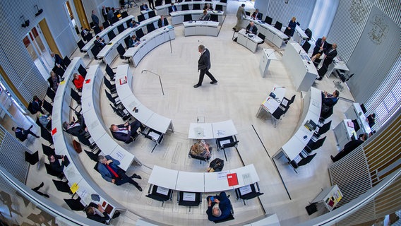 Im Landtag von Mecklenburg-Vorpommern treffen sich die Abgeordneten treffen sich zu einer Sitzung und sitzen mit großen Abständen im Saal. © dpa Foto: Jens Büttner