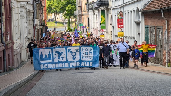 Demonstranten laufen mit einem Banner "Schwerin für alle" durch die schweriner Innenstadt. © Chris Loose Foto: Chris Loose