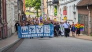Demonstranten laufen mit einem Banner "Schwerin für alle" durch die schweriner Innenstadt. © Chris Loose Foto: Chris Loose