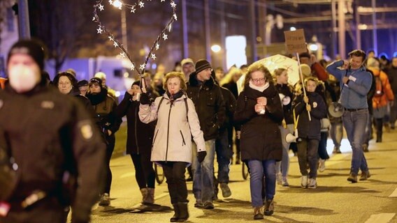 Teilnehmer einer Demonstration gegen Corona-Maßnahmen und Impfpflicht ziehen durch die Rostocker Südstadt. © dpa Foto: Bernd Wüstneck