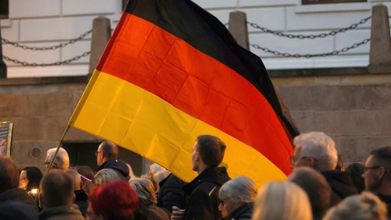 In mehreren Städten von Mecklenburg-Vorpommern ist am Montag (10. Oktober) erneut gegen die aktuelle Energiepolitik demonstriert worden - hier Teilnehmer mit einer Deutschlandfahne in Schwerin. © dpa Foto: Bernd Wüstneck
